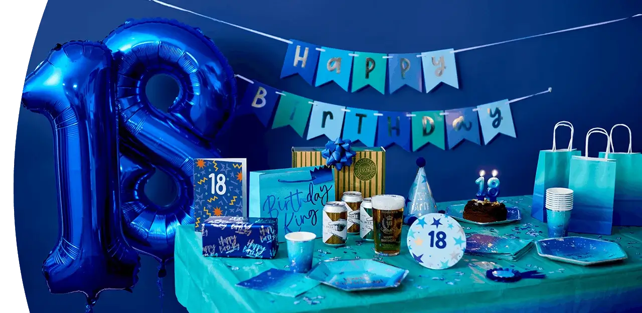 18th birthday party table with blue number 18 balloons, birthday banner, cake, party tableware, gift bags, drinks, and blue party decorations.