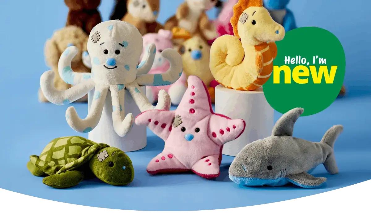 A group of soft plush sea animal toys arranged on a blue background, including an octopus, starfish, turtle, seahorse, and shark, with a green badge reading hello, I’m new.