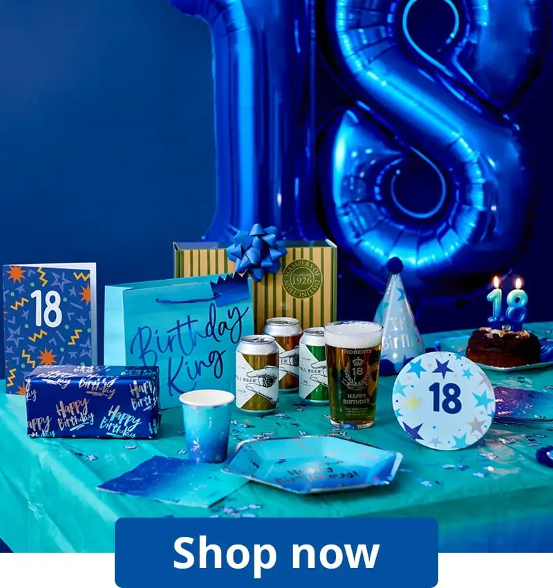 18th birthday party table with blue number balloons, a birthday cake, party tableware, gift bags, drinks, and birthday decorations.