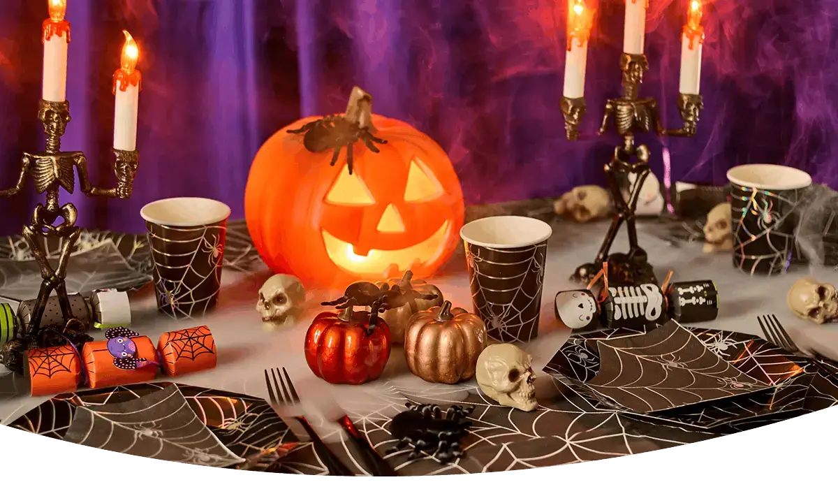 Halloween Boo Box filled with spooky toys, glow accessories, decorations and a plush skeleton character, displayed with cobwebs and smoke effects against a purple background.