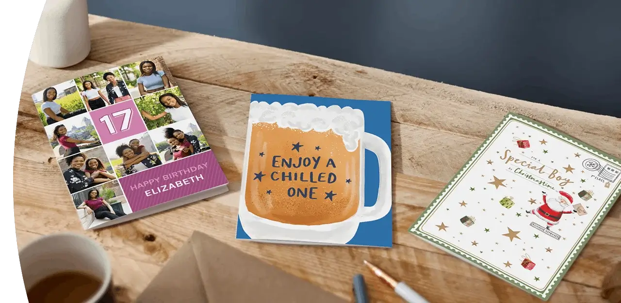 Selection of greeting cards including personalised photo cards, a character-themed birthday card, and a humorous birthday card displayed on a wooden table. Selection of greeting cards including personalised photo cards, a character-themed birthday card, and a humorous birthday card displayed on a wooden table.