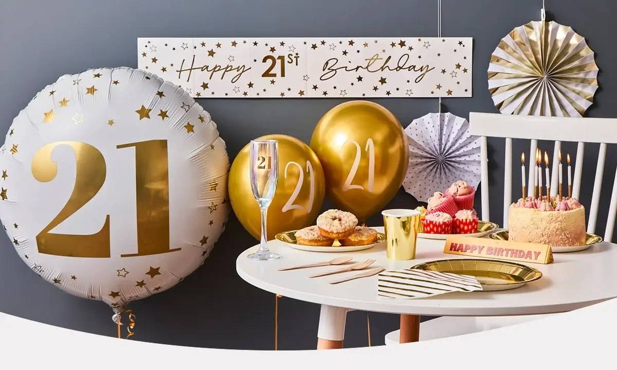 21st birthday setup with gold balloons, champagne flute, cake, cupcakes, donuts, and a Happy 21st Birthday banner.