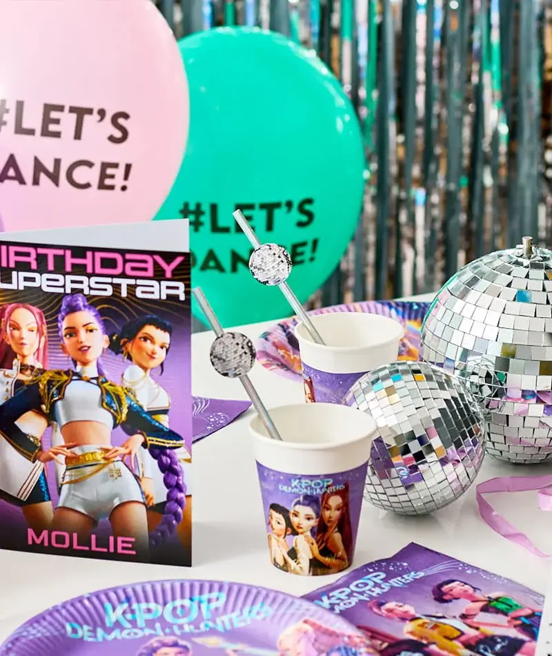 KPop Demon Hunters themed party table with branded plates, cups, disco ball decorations, balloons, and matching party accessories. KPop Demon Hunters themed party table with branded plates, cups, disco ball decorations, balloons, and matching party accessories.