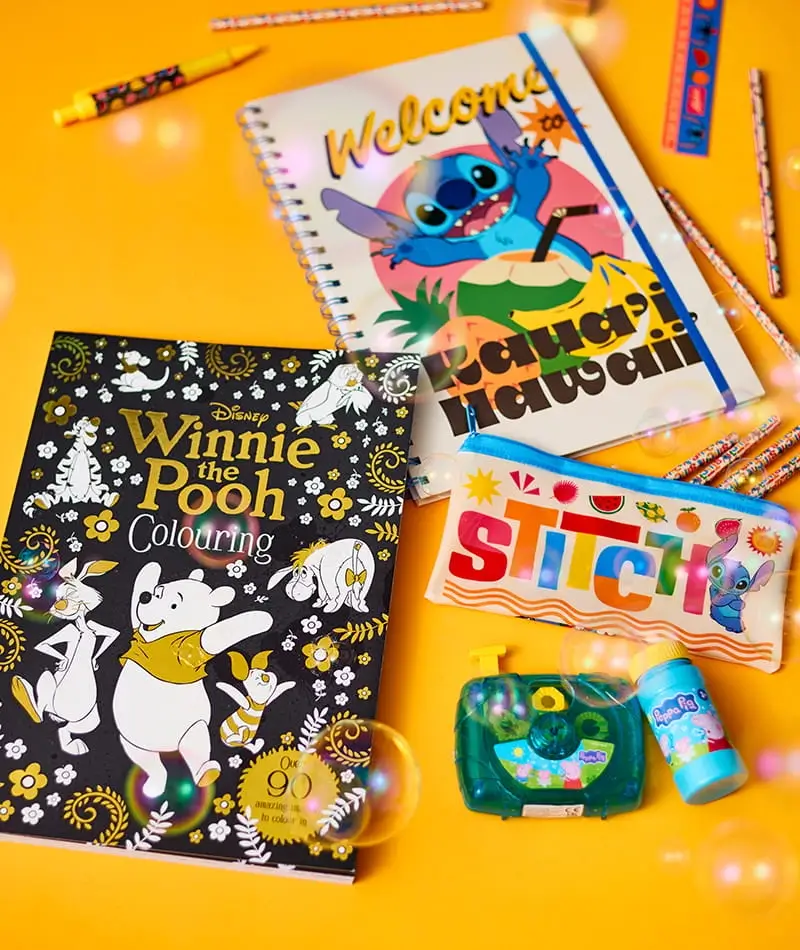 Disney-themed stationery and activity set featuring a Stitch notebook, pencil case, colouring book, bubble mixture and toy camera on a bright yellow background.
