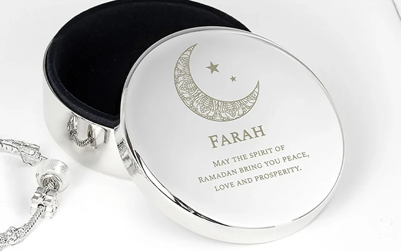 A round silver keepsake box with a decorative crescent moon and star design, personalised with the name ‘Farah’ and an engraved Ramadan blessing on the lid.