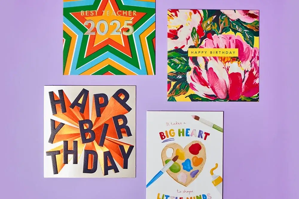 'Four colorful greeting cards on a purple background. The top left card has a star design with the text 'Best Teacher 2025'. The top right card features vibrant flowers with the text 'Happy Birthday'. The bottom left card has bold, orange and black letters spelling out 'Happy Birthday'. The bottom right card shows a painter's palette with the text 'It takes a big heart to shape little minds' 'Four colorful greeting cards on a purple background. The top left card has a star design with the text 'Best Teacher 2025'. The top right card features vibrant flowers with the text 'Happy Birthday'. The bottom left card has bold, orange and black letters spelling out 'Happy Birthday'. The bottom right card shows a painter's palette with the text 'It takes a big heart to shape little minds'