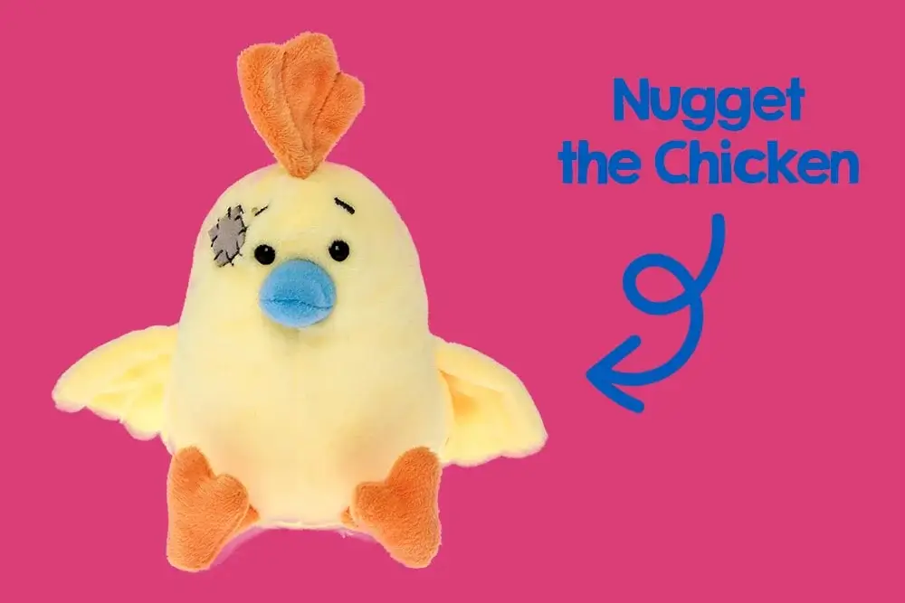 A plush toy resembling a bird with a yellow body, orange feet and crest, blue beak, and a stitched patch over one eye. The background is pink. A plush toy resembling a bird with a yellow body, orange feet and crest, blue beak, and a stitched patch over one eye. The background is pink.