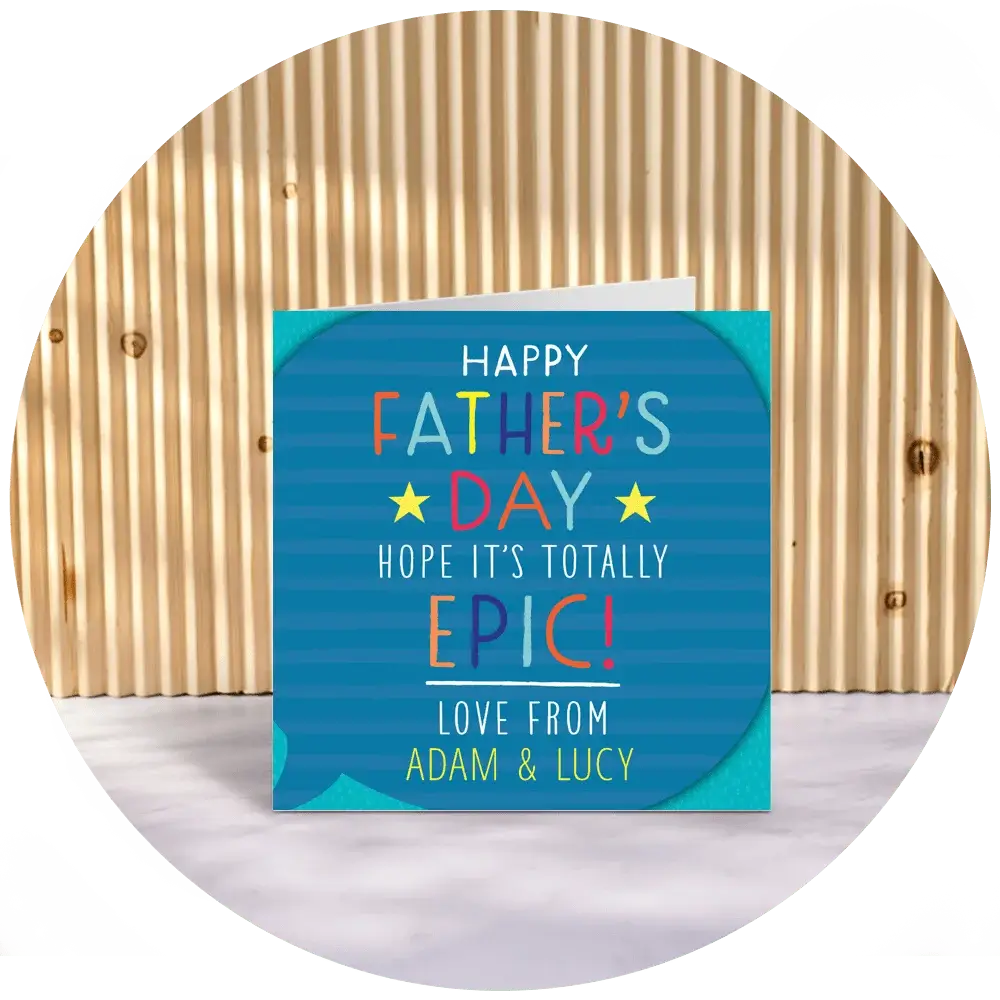 A square Father’s Day card with a blue dotted background and bold colourful lettering reading ‘Happy Father’s Day, Hope it’s Totally Epic!’ with the names ‘Adam & Lucy’ printed below, displayed upright against a wooden slatted backdrop. A square Father’s Day card with a blue dotted background and bold colourful lettering reading ‘Happy Father’s Day, Hope it’s Totally Epic!’ with the names ‘Adam & Lucy’ printed below, displayed upright against a wooden slatted backdrop.