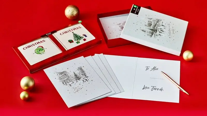 Cozy Christmas scene with personalized pillow, red stocking, plush bunny, maracas, and elf snow globe near a decorated tree.