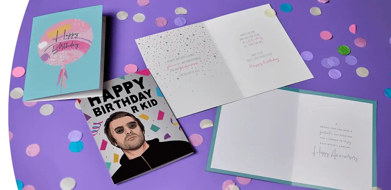 Selection of colourful greeting cards, including birthday and anniversary designs, displayed on a purple background with scattered confetti. Selection of colourful greeting cards, including birthday and anniversary designs, displayed on a purple background with scattered confetti.