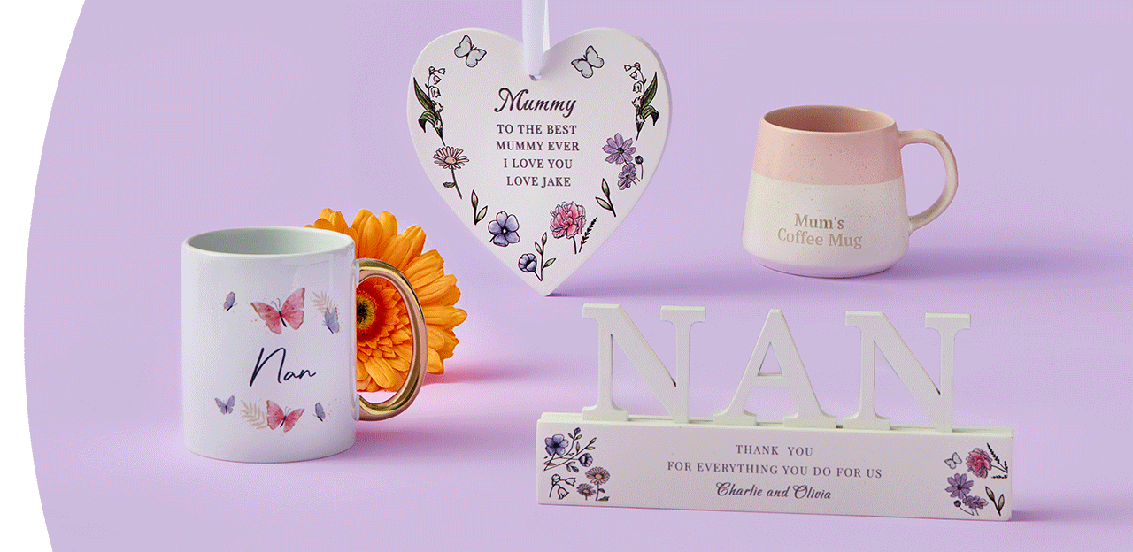 Butterfly‑themed Nan mug, a pink and cream Mum’s coffee mug, a floral heart plaque with a loving message, and a decorative NAN sign arranged together on a pastel purple background. Butterfly‑themed Nan mug, a pink and cream Mum’s coffee mug, a floral heart plaque with a loving message, and a decorative NAN sign arranged together on a pastel purple background.