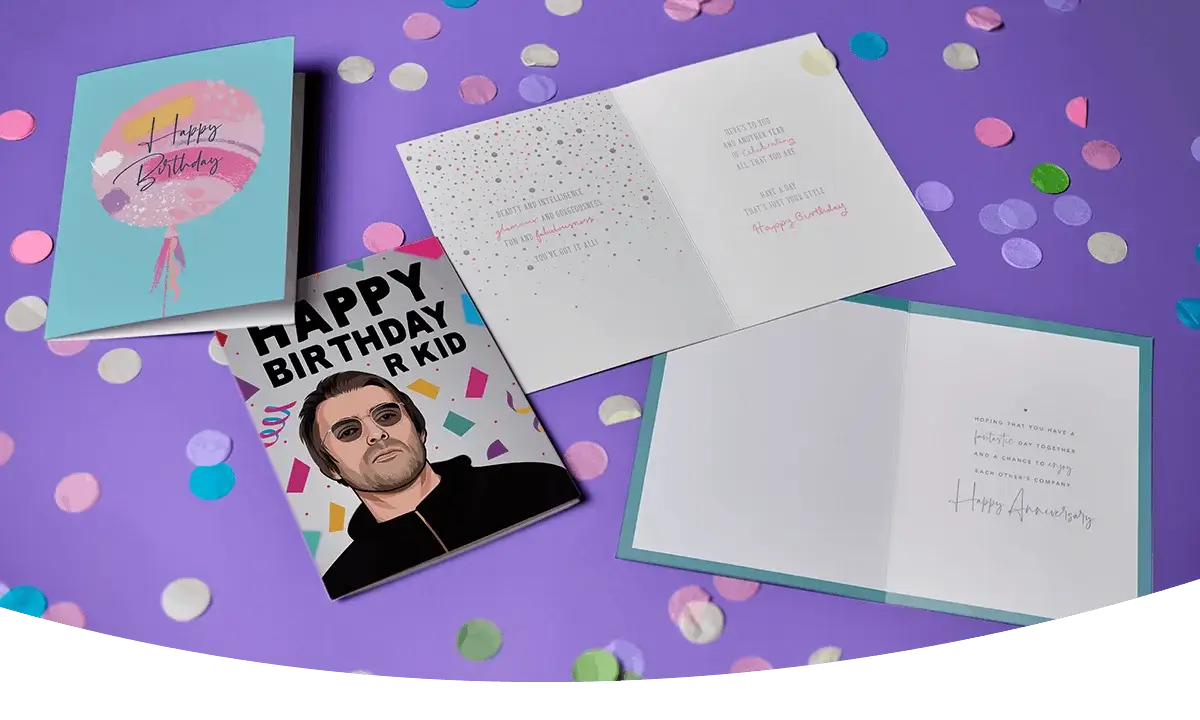 Selection of colourful greeting cards, including birthday and anniversary designs, displayed on a purple background with scattered confetti. Selection of colourful greeting cards, including birthday and anniversary designs, displayed on a purple background with scattered confetti.