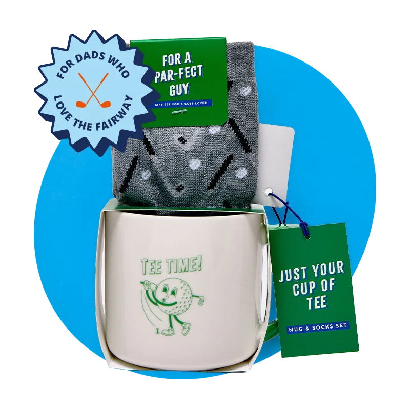 A golf‑themed gift set including a white mug printed with ‘Tee Time!’ and a cartoon golf ball, paired with grey patterned socks and green gift tags reading ‘For a par‑fect guy’ and ‘Just your cup of tee,’ displayed against a blue background with a ‘For dads who love the fairway’ badge. A golf‑themed gift set including a white mug printed with ‘Tee Time!’ and a cartoon golf ball, paired with grey patterned socks and green gift tags reading ‘For a par‑fect guy’ and ‘Just your cup of tee,’ displayed against a blue background with a ‘For dads who love the fairway’ badge.