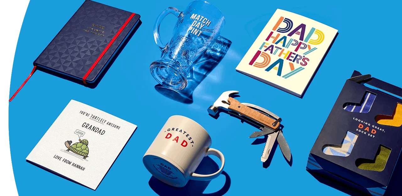 Father’s Day gift selection on blue background including a Dad mug, match day pint glass, greeting cards, multi-tool, notebook, and boxed socks
