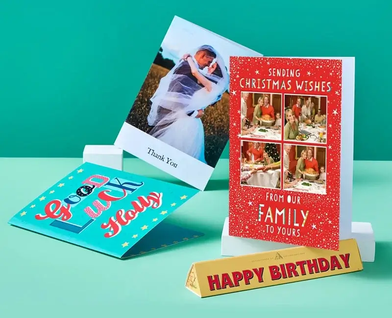 Greeting cards and a birthday gift box displayed on a green background, featuring messages like 'Sweet 16,' 'Thank You,' and 'Good Luck Holly.'