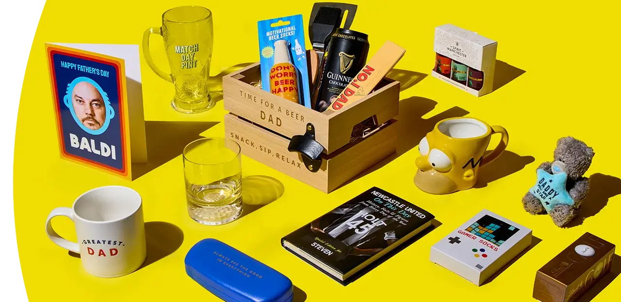 A Father’s Day gift display with a wooden crate filled with beer and snacks, surrounded by mugs, a glass, novelty socks, a book, cards and small gifts on a bright yellow background.
A Father’s Day gift display with a wooden crate filled with beer and snacks, surrounded by mugs, a glass, novelty socks, a book, cards and small gifts on a bright yellow background.