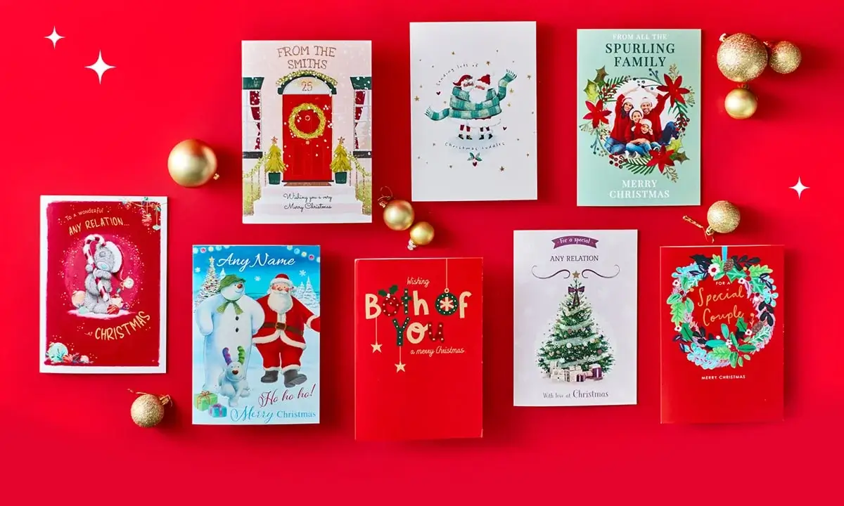 A collection of eight festive Christmas cards arranged on a bright red background with gold ornaments scattered around. The cards feature various designs, including a teddy bear in a Santa hat, a red door with wreath, a penguin with gifts, a family photo card, Santa and snowman illustration, bold red typography, a decorated Christmas tree, and a wreath with Special Couple text. A collection of eight festive Christmas cards arranged on a bright red background with gold ornaments scattered around. The cards feature various designs, including a teddy bear in a Santa hat, a red door with wreath, a penguin with gifts, a family photo card, Santa and snowman illustration, bold red typography, a decorated Christmas tree, and a wreath with Special Couple text.