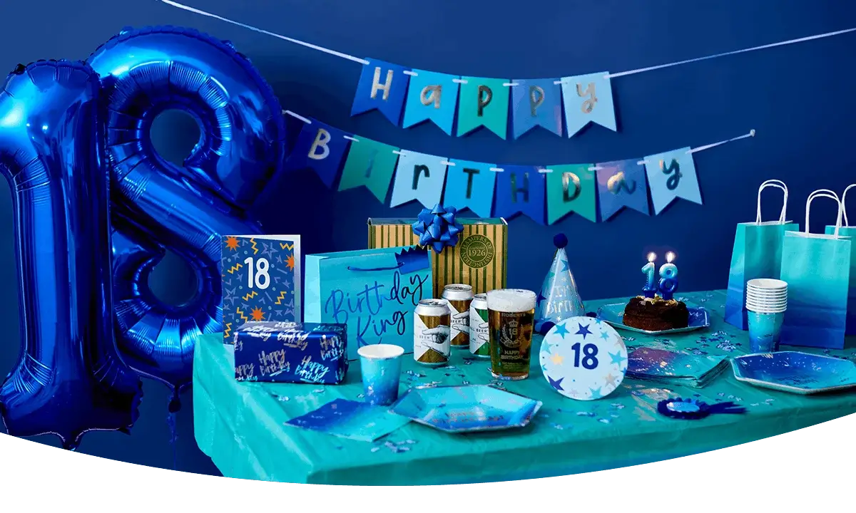 18th birthday party table with blue number 18 balloons, birthday banner, cake, party tableware, gift bags, drinks, and blue party decorations.