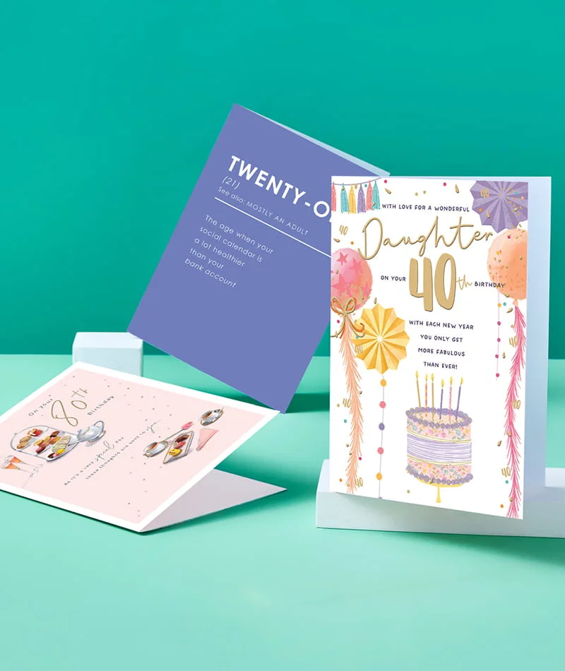 Selection of milestone birthday cards including 40th, 50th, and 21st designs displayed on a teal background