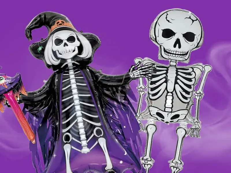 Halloween skeleton decorations featuring a skeleton witch balloon and a hanging skeleton cut-out against a purple spooky-themed background.