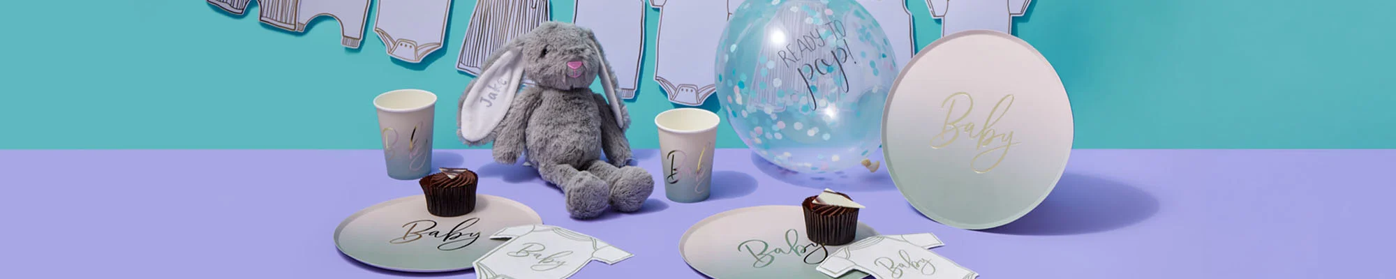 A personalised baby shower table display featuring ombré ‘Baby’ plates and cups, baby bodysuit-shaped napkins, a clear confetti balloon printed ‘Ready to Pop!’, and a grey personalised bunny soft toy with a name embroidered on the ear. Baby-clothes bunting hangs across a turquoise backdrop, creating a coordinated baby shower celebration setup. A personalised baby shower table display featuring ombré ‘Baby’ plates and cups, baby bodysuit-shaped napkins, a clear confetti balloon printed ‘Ready to Pop!’, and a grey personalised bunny soft toy with a name embroidered on the ear. Baby-clothes bunting hangs across a turquoise backdrop, creating a coordinated baby shower celebration setup.