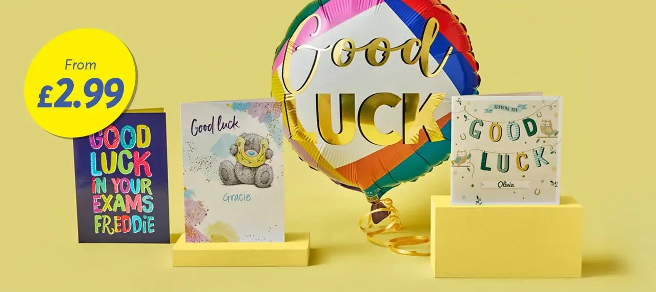 'The image shows a yellow background with three good luck cards and a colorful balloon. The first card on the left reads 'GOOD LUCK IN YOUR EXAMS FREDDIE' in multicolored letters. The middle card features a teddy bear and says 'Good Luck Gracie'. The third card on the right has the text 'GOOD LUCK Olivia' with decorative elements. A large, round balloon with rainbow colors and gold text saying 'Good Luck' is positioned behind the cards.'