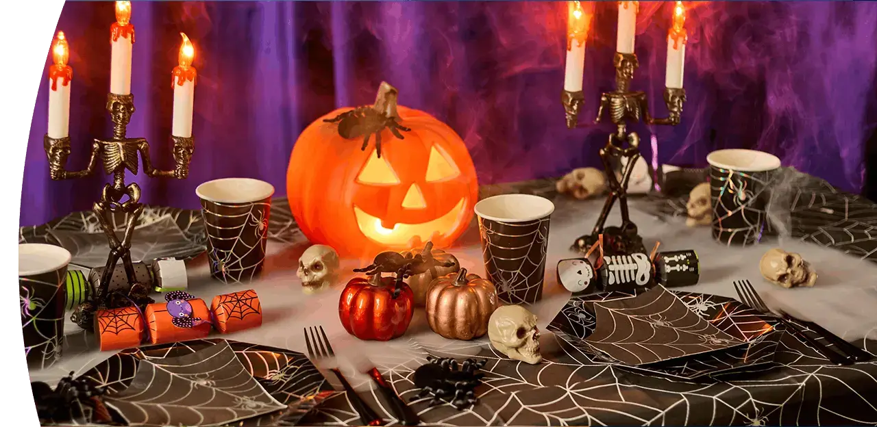 Halloween Boo Box filled with spooky toys, glow accessories, decorations and a plush skeleton character, displayed with cobwebs and smoke effects against a purple background.