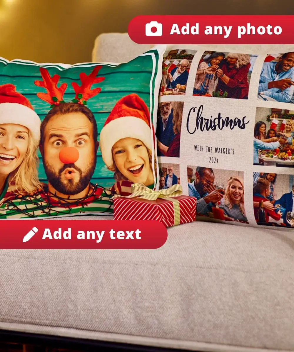 Two personalised photo cushions with Christmas designs placed on a sofa, accompanied by a small wrapped gift box with a gold ribbon.