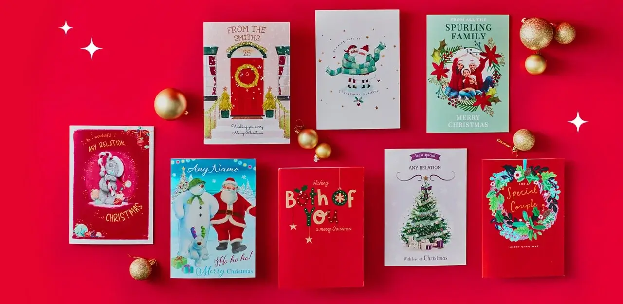 A collection of eight festive Christmas cards arranged on a bright red background with gold ornaments scattered around. The cards feature various designs, including a teddy bear in a Santa hat, a red door with wreath, a penguin with gifts, a family photo card, Santa and snowman illustration, bold red typography, a decorated Christmas tree, and a wreath with Special Couple text. A collection of eight festive Christmas cards arranged on a bright red background with gold ornaments scattered around. The cards feature various designs, including a teddy bear in a Santa hat, a red door with wreath, a penguin with gifts, a family photo card, Santa and snowman illustration, bold red typography, a decorated Christmas tree, and a wreath with Special Couple text.