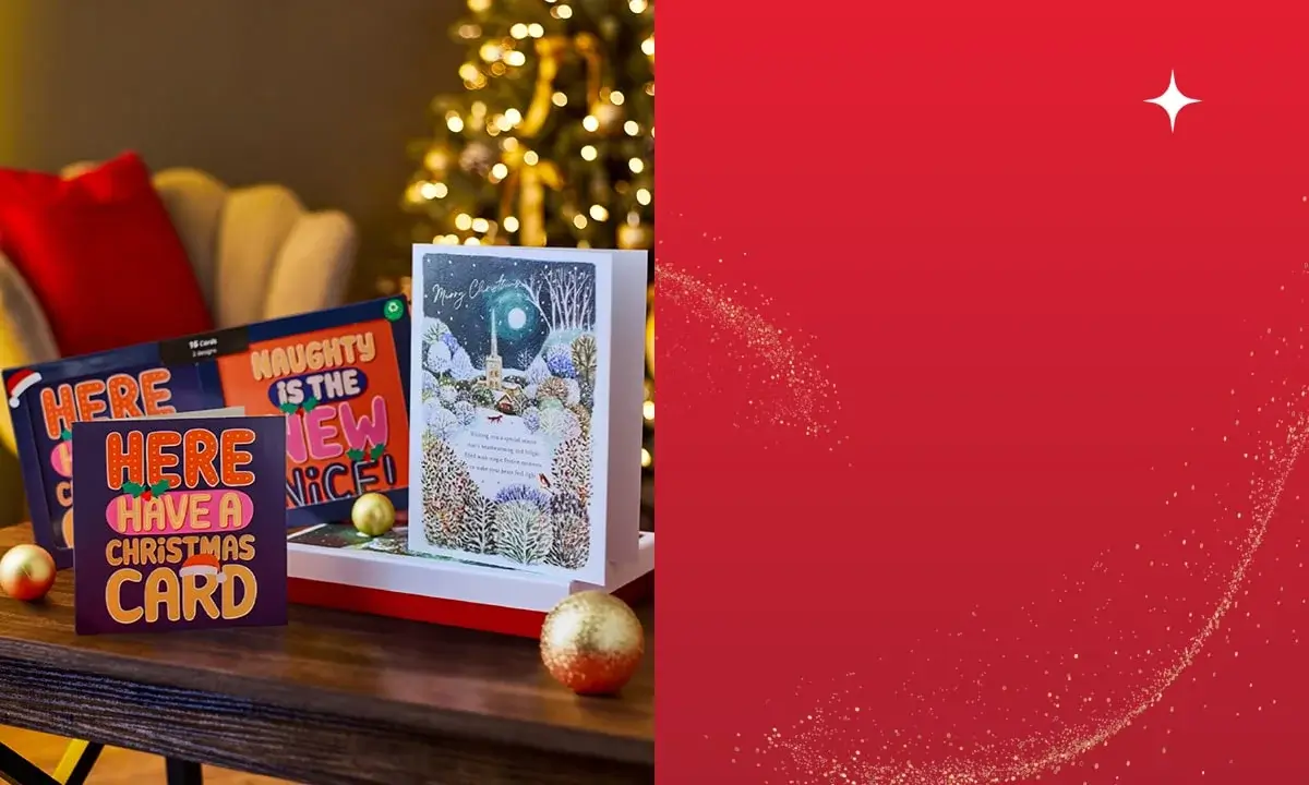 Festive scene with three Christmas cards on a wooden table alongside two gold ornaments, featuring bold and playful designs with messages HERE HAVE A CHRISTMAS CARD, NAUGHTY IS THE NEW NICE, and Merry Christmas, set against a blurred background of a decorated Christmas tree. Festive scene with three Christmas cards on a wooden table alongside two gold ornaments, featuring bold and playful designs with messages HERE HAVE A CHRISTMAS CARD, NAUGHTY IS THE NEW NICE, and Merry Christmas, set against a blurred background of a decorated Christmas tree.
