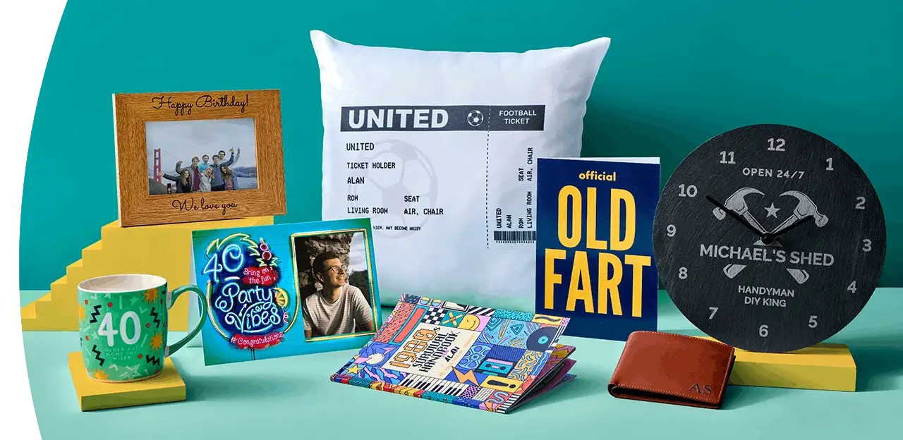 A display of personalised photo gifts on a peach background, including a photo frame, greeting cards, a birthday gift bag, a photo mug, and wrapped photo prints.