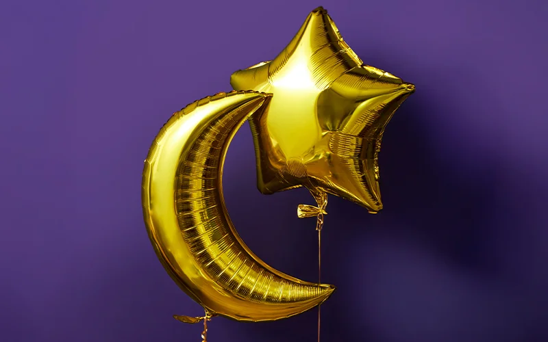 A gold foil crescent‑moon balloon paired with a gold star‑shaped balloon, displayed against a purple background.