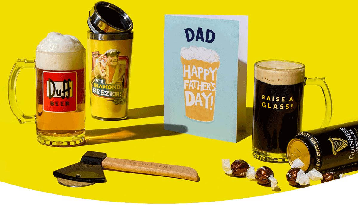 Father’s Day gift selection with beer mugs, a novelty glass, chocolates, tool, and card arranged on a bright yellow background