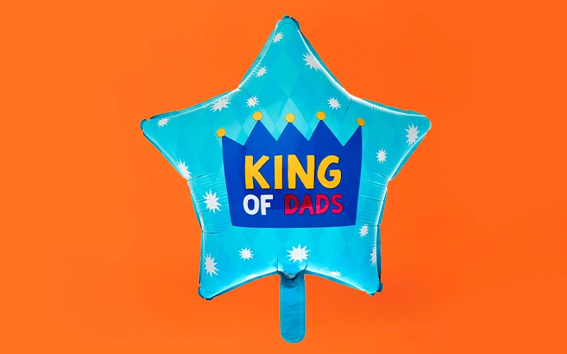 A Father’s Day balloon arrangement featuring a blue star‑shaped balloon with a crown design and the text ‘King of Dads,’ paired with two gold star balloons, displayed against a bright orange background with a yellow ‘In-store only’ label. A Father’s Day balloon arrangement featuring a blue star‑shaped balloon with a crown design and the text ‘King of Dads,’ paired with two gold star balloons, displayed against a bright orange background with a yellow ‘In-store only’ label.