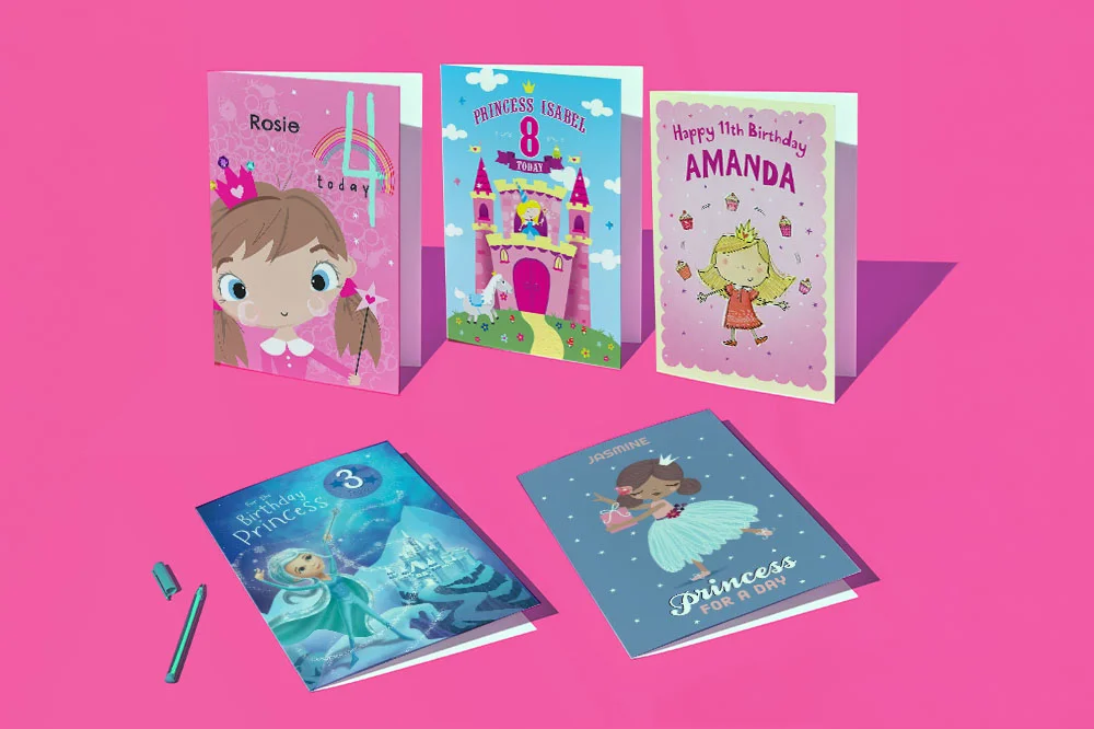 A selection of personalised princess birthday cards arranged on a bright pink background, including designs featuring princess characters, fairytale castles and magical scenes, with custom names and ages displayed on the fronts. Two cards are shown open alongside a pen to highlight personalisation options. A selection of personalised princess birthday cards arranged on a bright pink background, including designs featuring princess characters, fairytale castles and magical scenes, with custom names and ages displayed on the fronts. Two cards are shown open alongside a pen to highlight personalisation options.