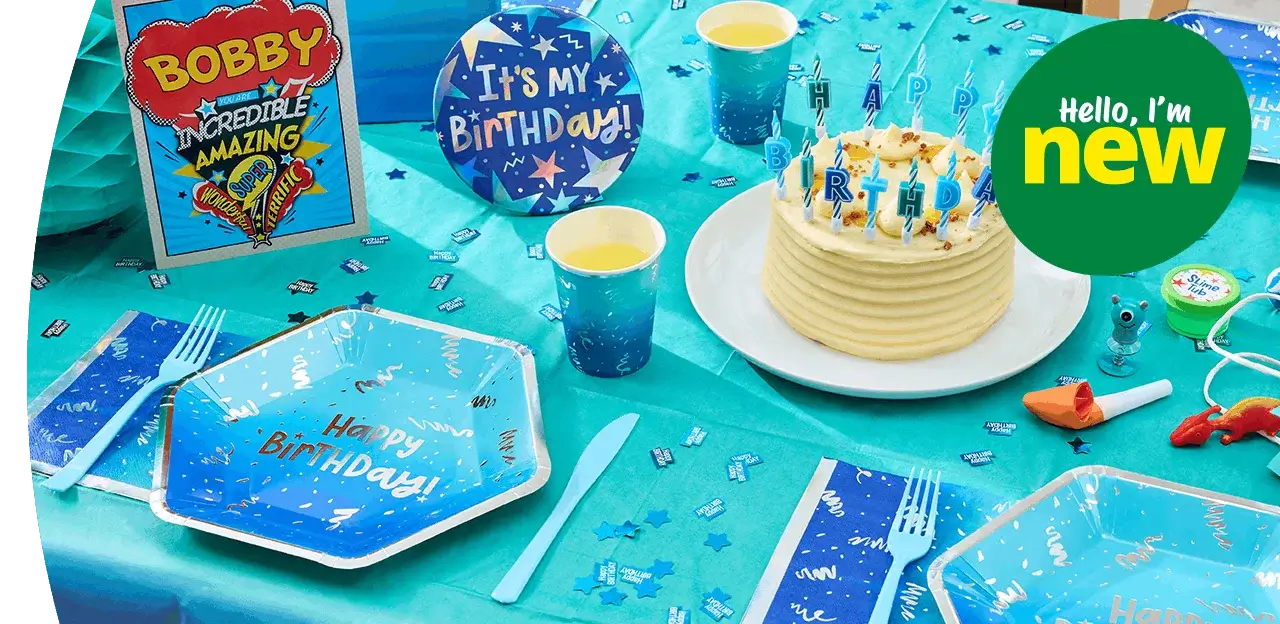 Blue birthday party table setting with a birthday cake, candles, themed plates and cups, party decorations, and scattered confetti on a turquoise tablecloth. Blue birthday party table setting with a birthday cake, candles, themed plates and cups, party decorations, and scattered confetti on a turquoise tablecloth.