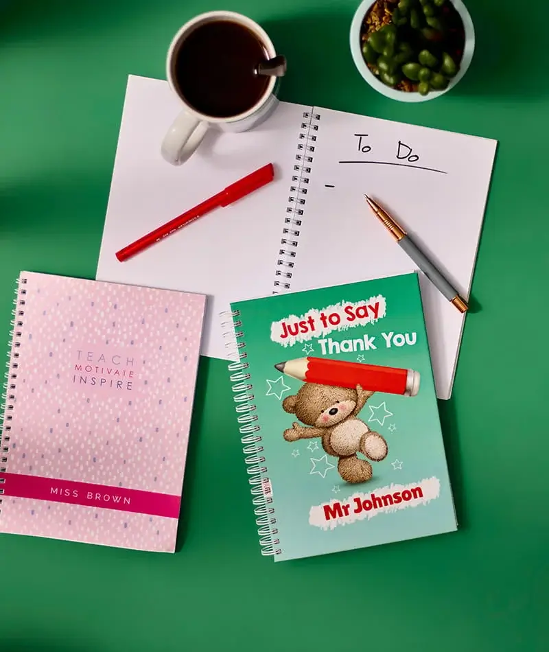 Notebooks and stationery including personalised teacher gift books, pens, and a to do list arranged on a green background Notebooks and stationery including personalised teacher gift books, pens, and a to do list arranged on a green background