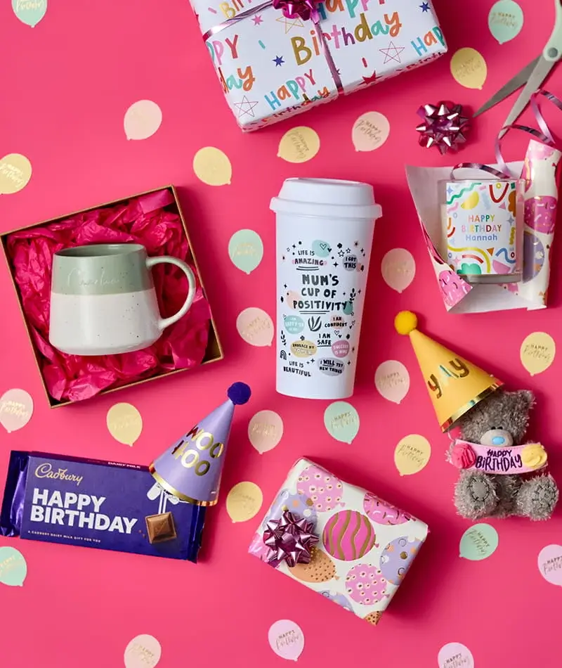 Birthday gift collection featuring personalised mugs, chocolates, wrapped presents, party hats, a teddy bear, and birthday-themed gift accessories on a pink background. Birthday gift collection featuring personalised mugs, chocolates, wrapped presents, party hats, a teddy bear, and birthday-themed gift accessories on a pink background.