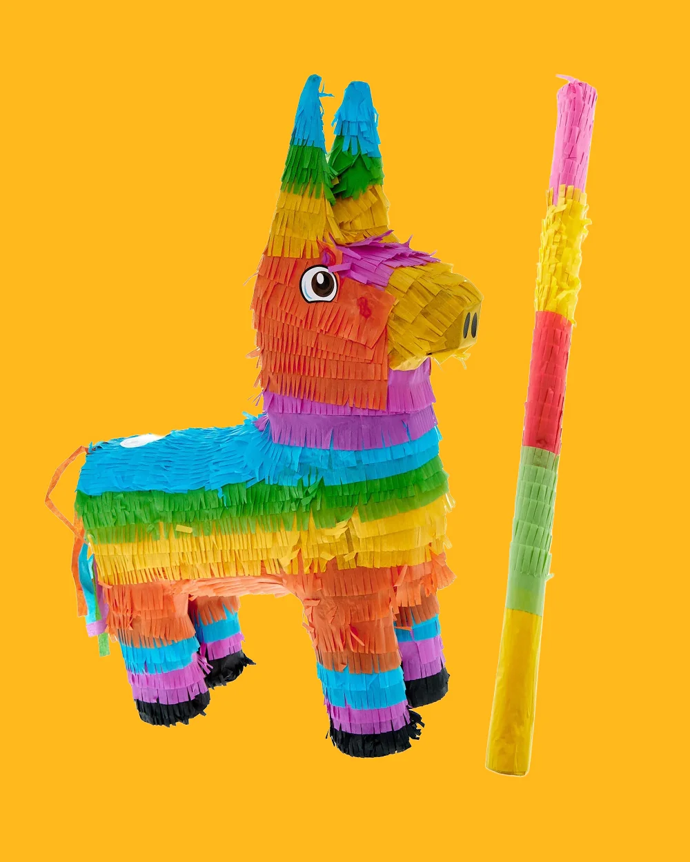 A colourful donkey-shaped piñata covered in layered fringe paper in rainbow colours including blue, green, yellow, orange, pink and purple, displayed beside a matching striped piñata stick against a bright yellow background. The party game accessory is designed for filling with sweets and treats for children's celebrations. A colourful donkey-shaped piñata covered in layered fringe paper in rainbow colours including blue, green, yellow, orange, pink and purple, displayed beside a matching striped piñata stick against a bright yellow background. The party game accessory is designed for filling with sweets and treats for children's celebrations.