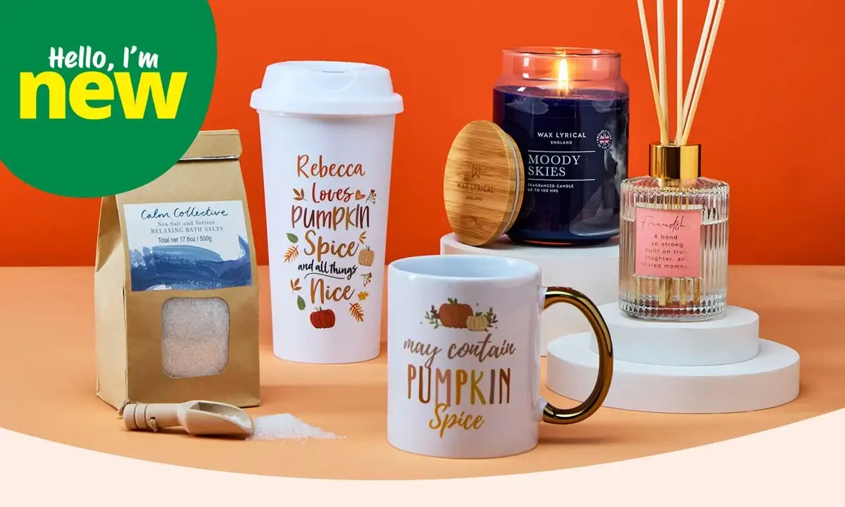 Autumn-themed product display on an orange background, featuring mugs, a candle, bath salts, and a reed diffuser, with a green 'Hello, I'm new' label