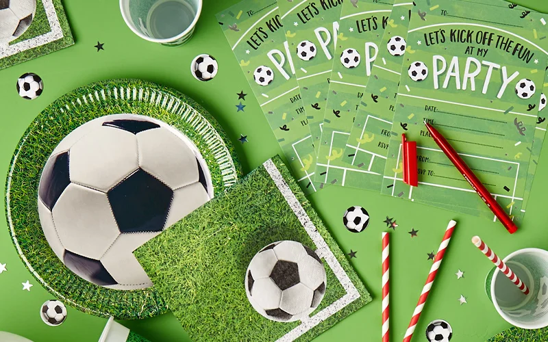 A football‑themed party stationery display featuring green invitations reading ‘Let’s Kick Off the Fun at My Party,’ alongside football decorations, paper cups, striped paper straws, confetti and football‑pitch patterned tableware on a bright green background. A football‑themed party stationery display featuring green invitations reading ‘Let’s Kick Off the Fun at My Party,’ alongside football decorations, paper cups, striped paper straws, confetti and football‑pitch patterned tableware on a bright green background.