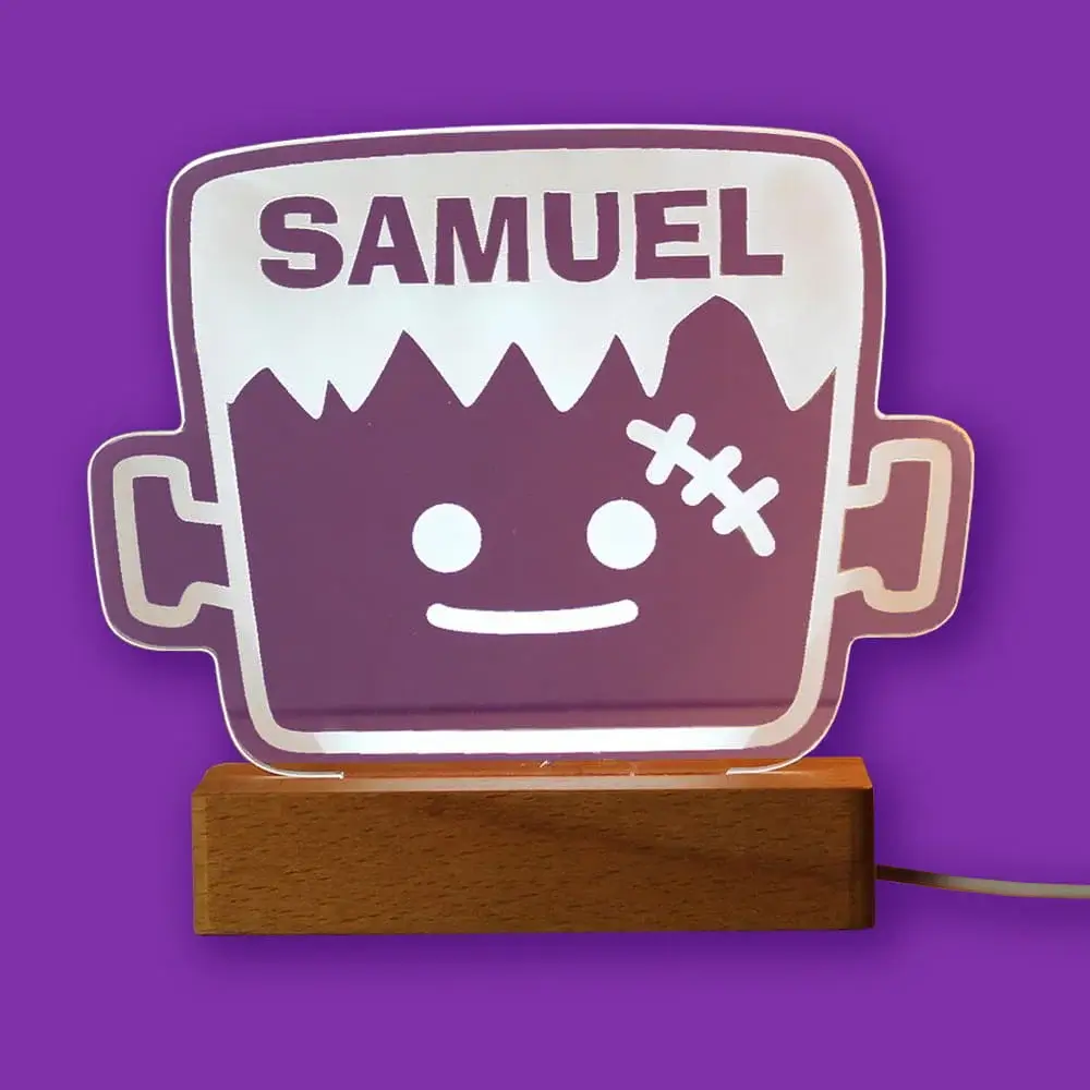 Personalised Frankenstein-themed LED night light with a custom name displayed on a wooden base against a purple background.