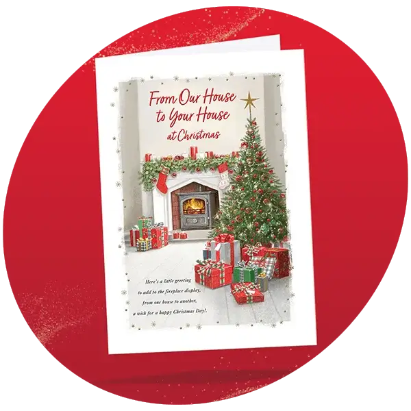 Christmas card showing a cozy living room with a decorated fireplace, Christmas tree, and wrapped presents, featuring the text From Our House to Your House at Christmas with a festive greeting.