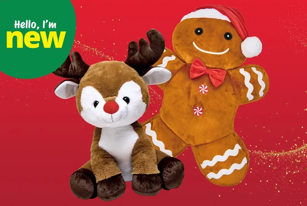 Two plush Christmas toys displayed against a bright red background with gold glitter accents: a soft brown reindeer with dark antlers and a smiling gingerbread figure wearing a Santa hat and red bow tie.