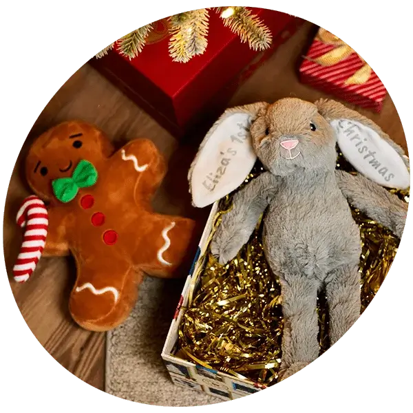Plush purple bunny and small fairy doll in a pink dress with wings, lying on a pink background.
