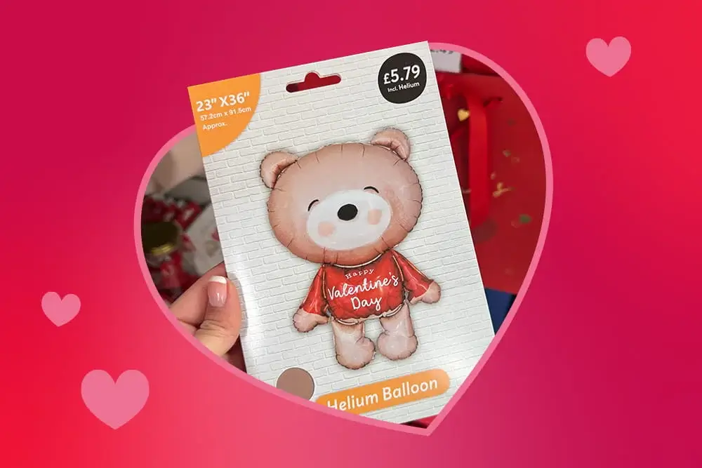 Cute teddy‑bear‑themed Valentine’s helium balloon package held up against a pink heart‑filled background.