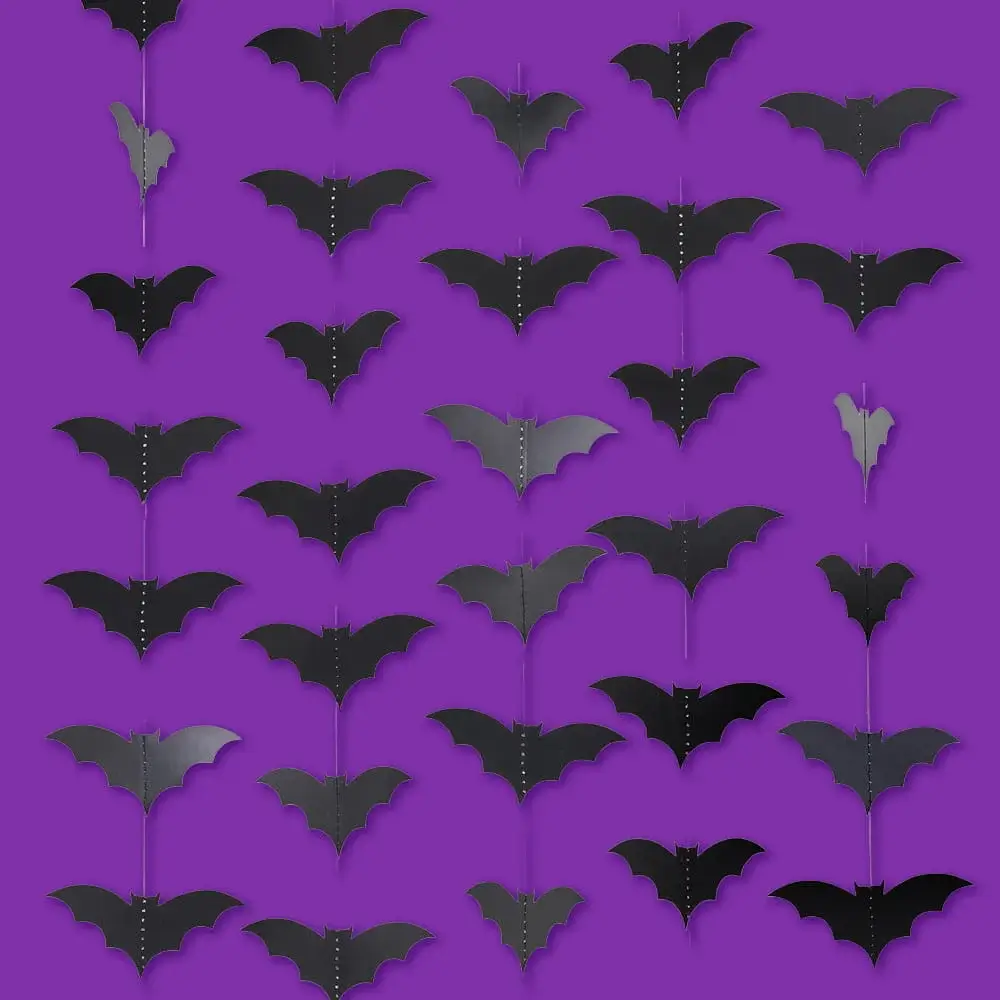Black hanging bat decorations displayed against a purple background, creating a spooky Halloween-themed backdrop.