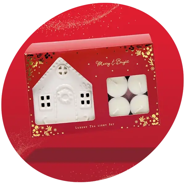 Luxury tea light set in a festive red box with gold accents, including a white ceramic house-shaped holder and four white tea light candles, with the text Merry and Bright and Luxury Tea Light Set on the box.