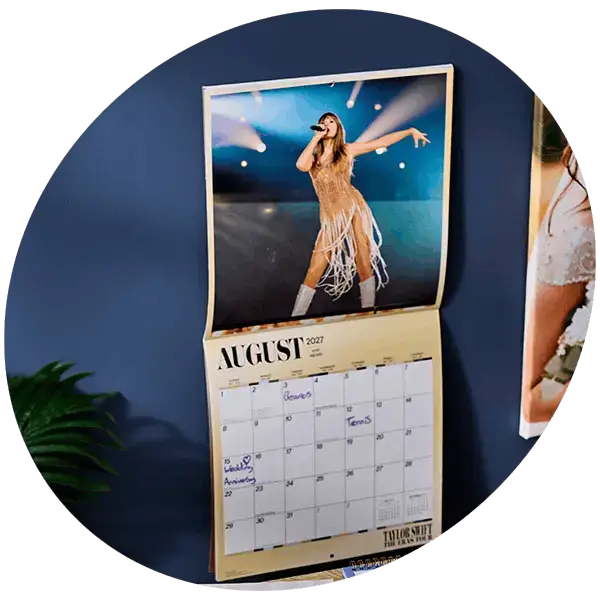 Personalised photo wall calendar featuring a concert photograph, displayed against a blue wall with a monthly calendar layout below the image.