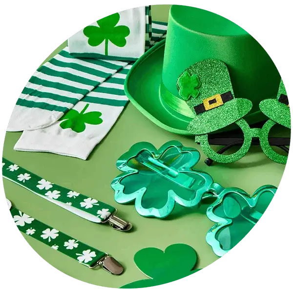 A collection of bright green St Patrick’s Day accessories, including a top hat, shamrock glasses, striped socks, and clover‑patterned items, arranged on a green background.